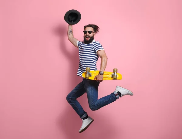 Hipster hombre saltando con longboard — Foto de Stock