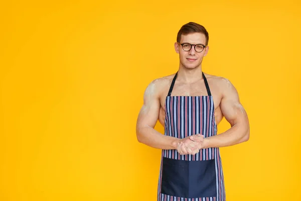 Muskulöser Mann posiert in Schürze im Studio — Stockfoto