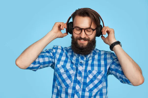 Homem elegante em fones de ouvido no fundo azul — Fotografia de Stock