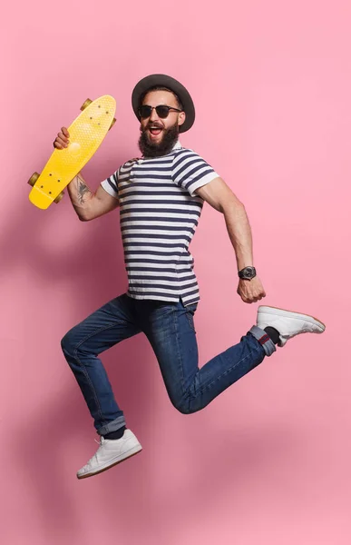 Homem animado pulando com longboard — Fotografia de Stock