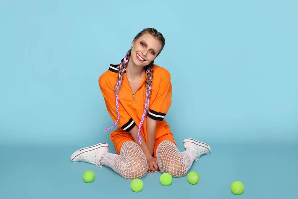 Trendy cheerful model with tennis balls — Stock Photo, Image