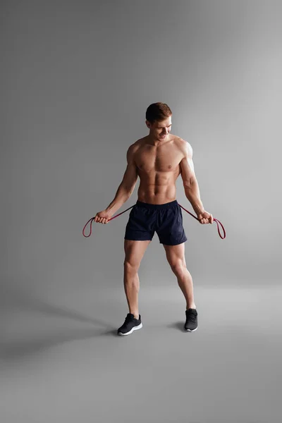 Sportive man with elastic band — Stock Photo, Image