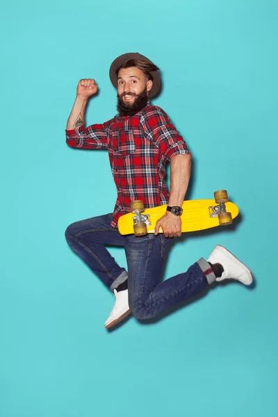 Energetic hipster jumping with longboard — Stock Photo, Image