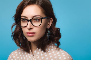 Gözlük ve küpe giyen genç esmer kadın