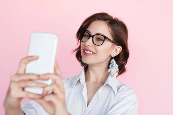 Mujer joven sosteniendo el teléfono haciendo selfie — Foto de Stock