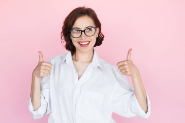 Smiling woman in glasses holding thumbs up clipart