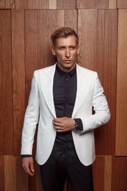 Ahşap duvar üzerinde takım elbiseli şık adam