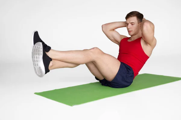 Homem concentrado treinando músculos abdominais — Fotografia de Stock