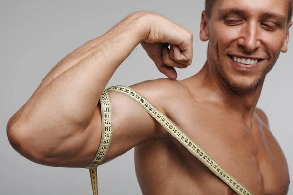 Cheerful man measuring bicep — Stock Photo, Image