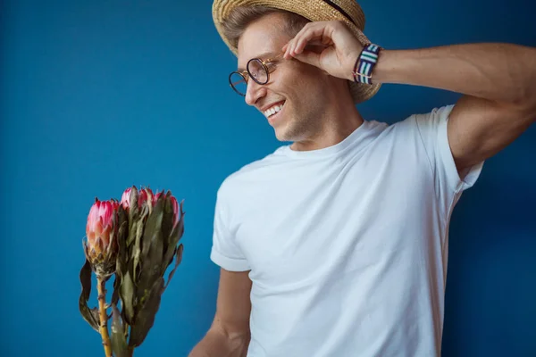 Hombre sonriente posando con flores —  Fotos de Stock
