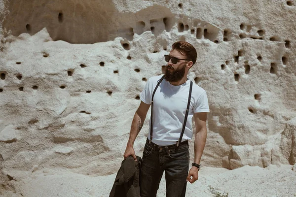 Homem elegante em pé na parede de pedra calcária — Fotografia de Stock