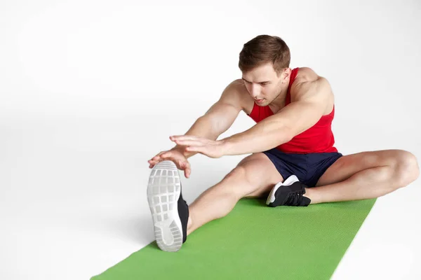 Young sportsman stretching on map — Stock Photo, Image