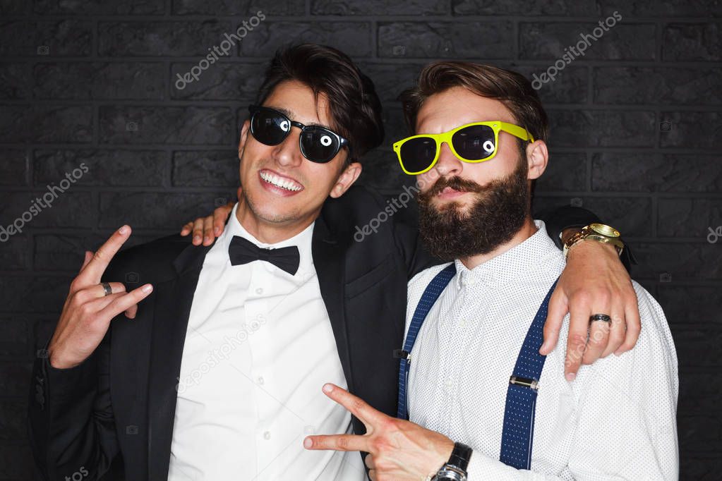 Two elegant men posing happily