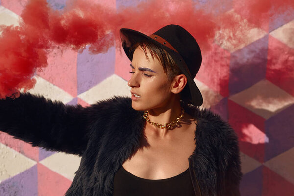 Trendy youngster with colored smoke