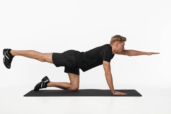 Hombre haciendo ejercicio sobre estera de yoga — Foto de Stock