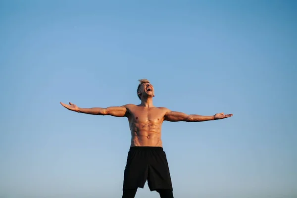 Muscular man screaming with hands apart — Stock Photo, Image