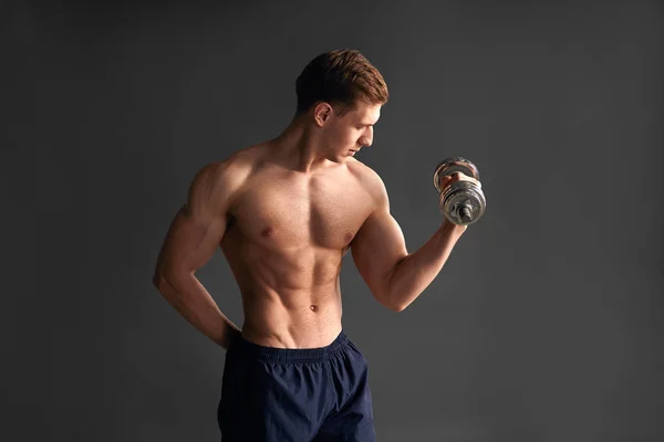 Bonito desportista treinando bíceps em estúdio — Fotografia de Stock