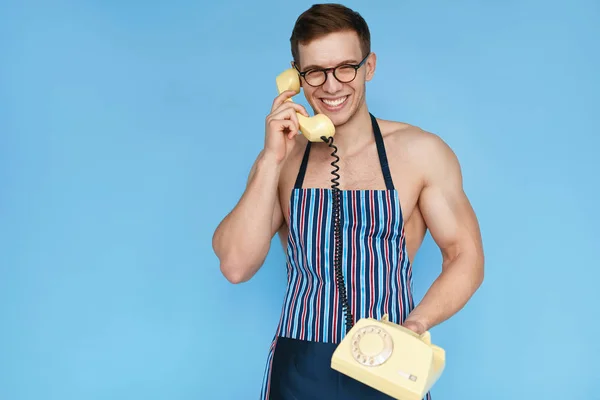 Deportista sonriente en delantal posando con teléfono — Foto de Stock