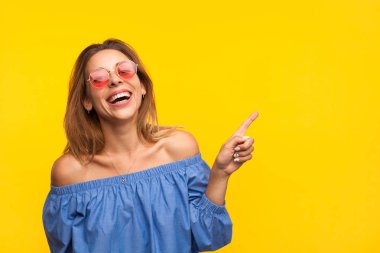 Boş alan işaret eden kadın gülüyor