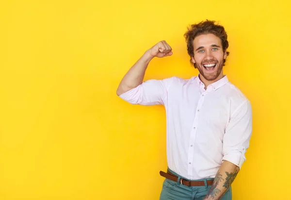 Cheerful man showing bicep — Stock Photo, Image