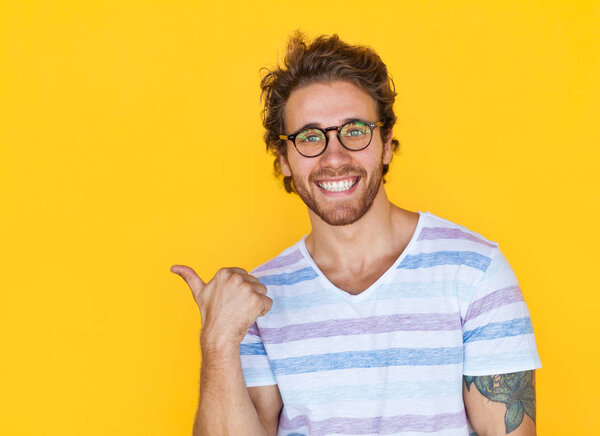 Smiling man pointing with thumb