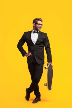 kaykay tutan takım elbiseli adam