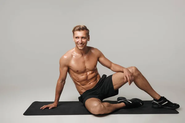Esportista muscular alegre posando no tapete — Fotografia de Stock