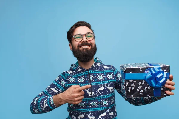 Um com barba segurando e apontando o dedo para a caixa de presente — Fotografia de Stock