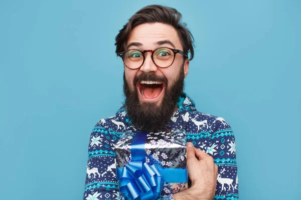 Jovem barbudo homem com embrulhado presente azul — Fotografia de Stock