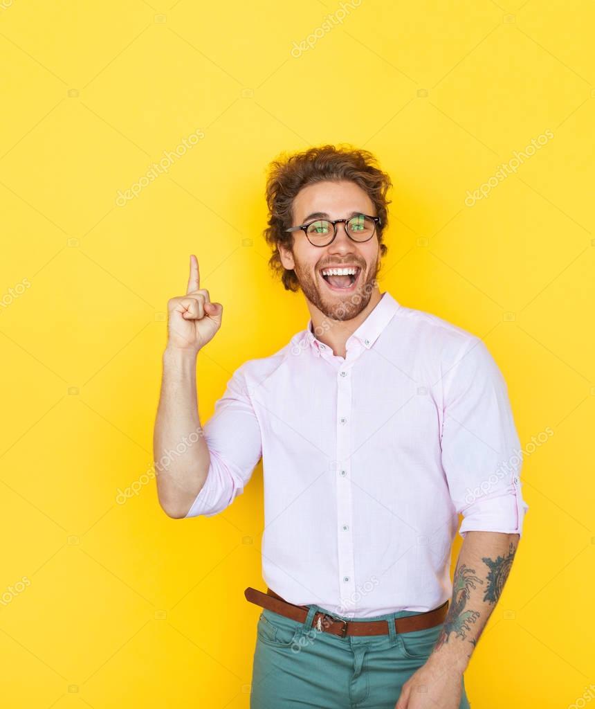 Young stylish man pointing up
