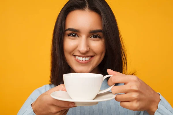 Joven hispana sonriendo y sosteniendo una taza de café —  Fotos de Stock