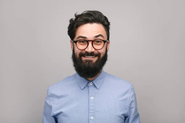 Улыбающийся бородатый мужчина в рубашке и очках — стоковое фото
