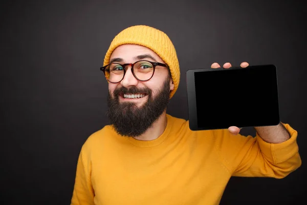 Χαμογελαστός άνθρωπος hipster δείχνει tablet — Φωτογραφία Αρχείου