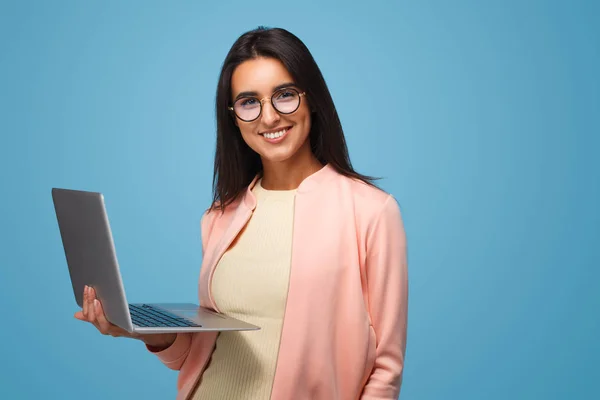 Slim meisje met laptop op blauw — Stockfoto