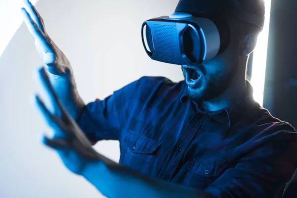 Scared guy in VR glasses exploring cyberspace — Stock Photo, Image