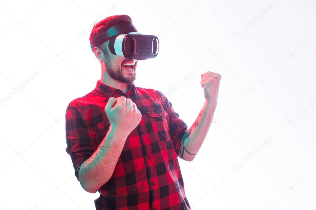 Victorious guy in VR goggles on white