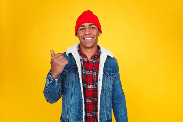 Sonriente negro chico mostrando lejos en amarillo — Foto de Stock