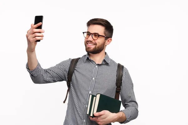 Homem confiante com livros tirando selfie — Fotografia de Stock