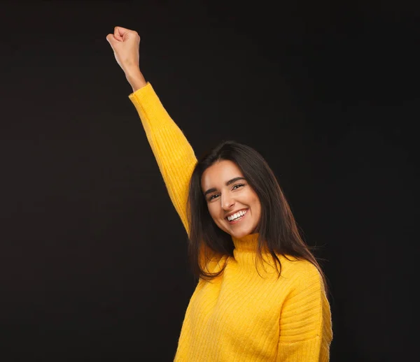 Excited girl gesturing in victory on black — Stock Photo, Image