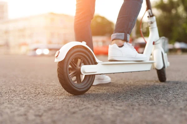 Crop hipster riding electric scooter on road — Stock Photo, Image