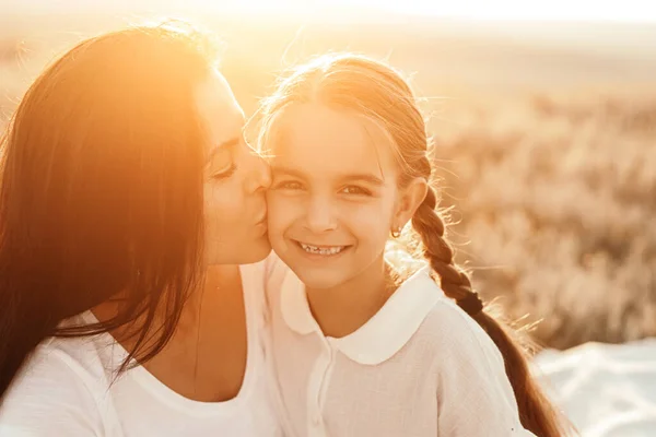 Mãe beijando filha na natureza — Fotografia de Stock