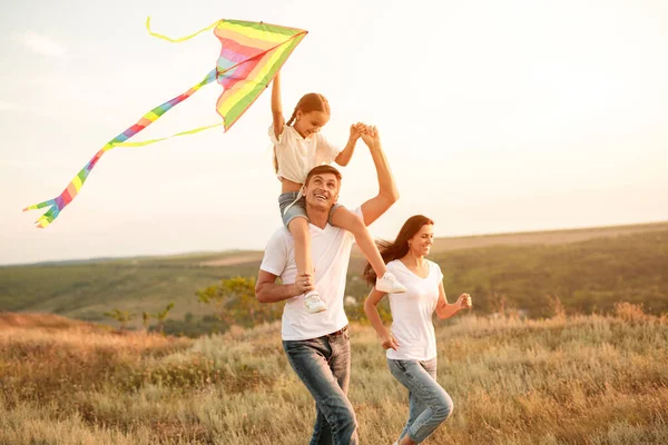 Rozkoszna rodzina biegająca z latawcem — Zdjęcie stockowe