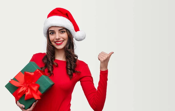 Senhora feliz com presente de Natal apontando para o espaço vazio — Fotografia de Stock