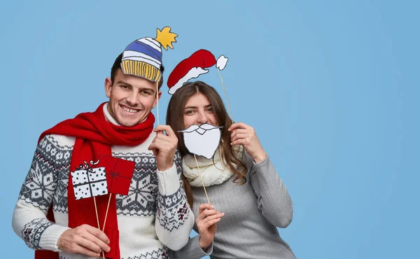 Casal alegre com adereços de pau durante a festa de Natal — Fotografia de Stock