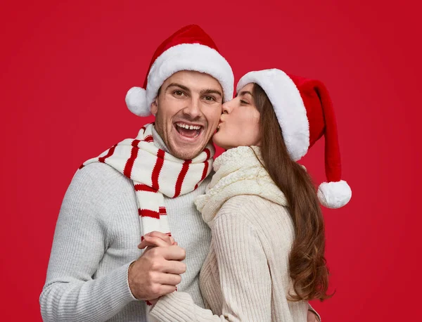 Mulher beijando namorado durante a festa de Natal — Fotografia de Stock