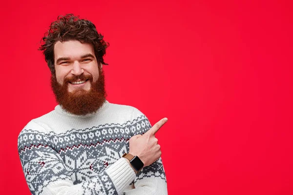 Chico feliz en suéter señalando a un lado —  Fotos de Stock