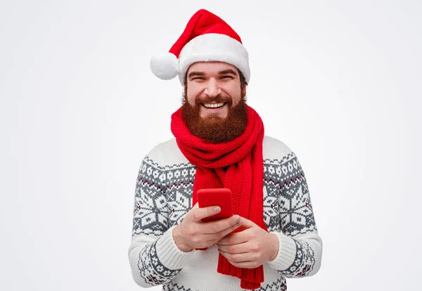 Веселый мужчина с помощью смартфона на Рождество — стоковое фото