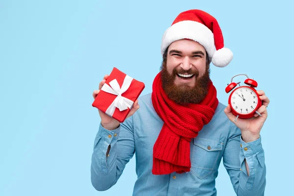 Cara alegre com presente de Natal e despertador — Fotografia de Stock