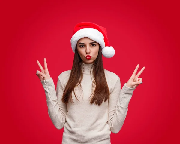 Stijlvol vrouwelijk gebaar V teken tijdens kerstfeest — Stockfoto