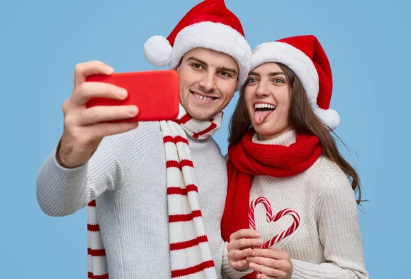 Funny couple making selfie with candy canes — Stock Photo, Image